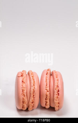 Bunte französische Macarons mit Erdbeeraroma auf weißem Hintergrund. Pastellfarben - Bild Stockfoto