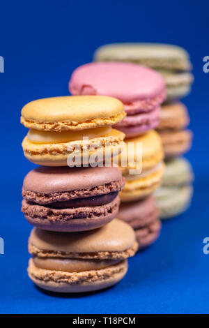 Bunte französische Macarons auf blauem Hintergrund isoliert. Pastellfarben - Imagen Stockfoto