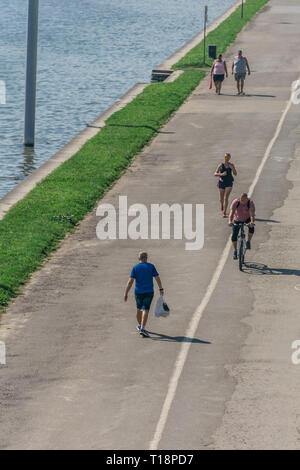 Krakau, Polen - 21. September 2019: Volk ist Wandern und Radfahren auf dem Radweg am Ufer der Weichsel, mit Kotlarski Brücke auf der Stockfoto