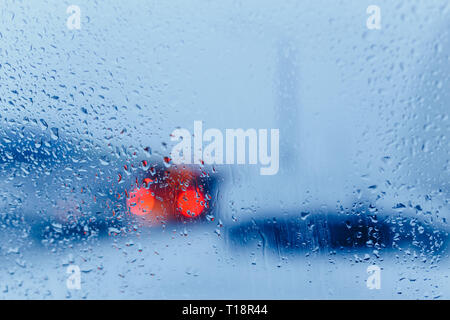 Verkehr Abstract in Regen. Verkehr von in einem Auto gesehen. Regentropfen auf der Windschutzscheibe und Auto Rückleuchten im Bokeh Stockfoto