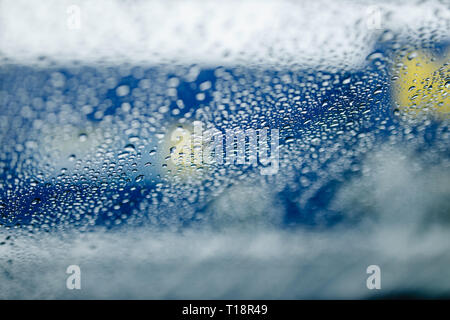 Verkehr Abstract in Regen. Verkehr von in einem Auto gesehen. Regentropfen auf der Windschutzscheibe und Auto Rückleuchten im Bokeh Stockfoto