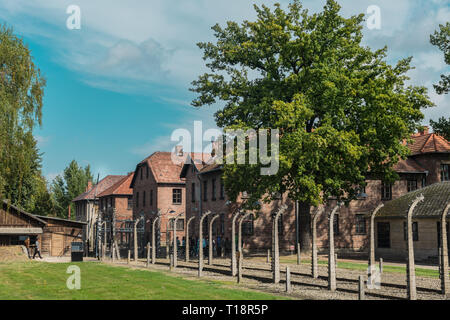 Oswiencim, Polen - 21. September 2019: Touristen, die über das Tor der nationalsozialistischen Konzentrationslager Auschwitz Stockfoto