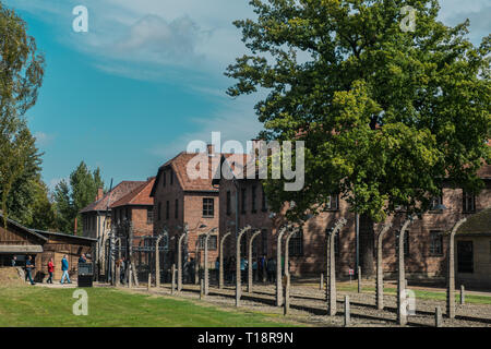 Oswiencim, Polen - 21. September 2019: Touristen, die über das Tor der nationalsozialistischen Konzentrationslager Auschwitz Stockfoto