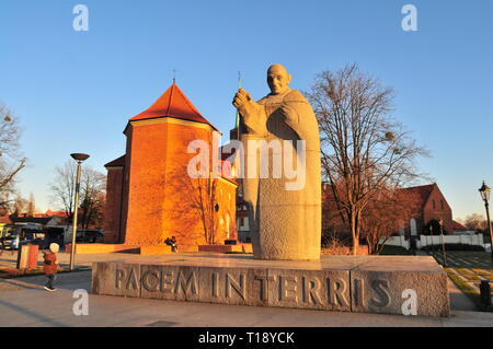 Papst Johannes XXIII. Granit Statue mit der Römisch-katholischen Kirche St. Marcin im Rücken. Wroclaw Ostrow Tumski. Polen Stockfoto