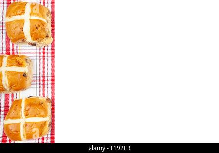 Weißer Hintergrund mit einem Hot Cross Buns auf einer rot-weißen pattened linke Grenze Stockfoto