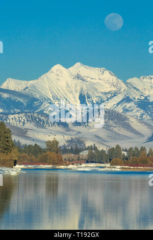 Mond über der flathead River und Mission Berge im Winter in der Nähe von Dixon, Montana Stockfoto