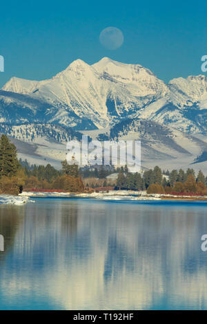 Mond über der flathead River und Mission Berge im Winter in der Nähe von Dixon, Montana Stockfoto