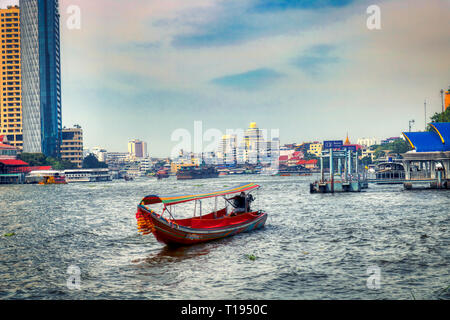 Dieses einzigartige Foto zeigt wie die alten traditionellen Long tail Boote an der Mae Nam Chao Phraya Fluss in Bangkok fahren Stockfoto