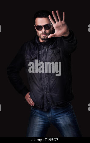 Hübscher junger Mann in der Sonnenbrille zeigt an stop Geste. Stockfoto
