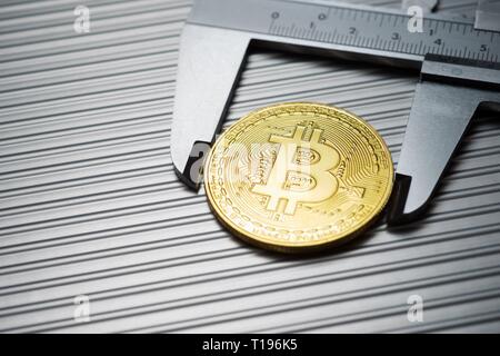 Bitcoin und Bremssattel auf einem Metalltisch. Stockfoto