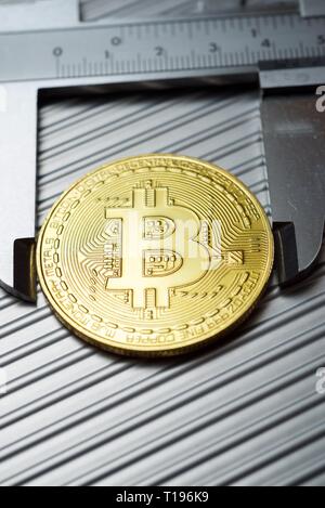 Bitcoin und Bremssattel auf einem Metalltisch. Stockfoto
