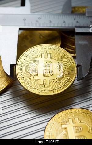 Bitcoins und Bremssattel auf einem Metalltisch. Stockfoto