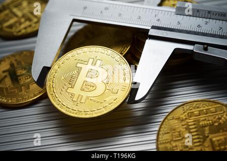 Bitcoins und Bremssattel auf einem Metalltisch. Stockfoto