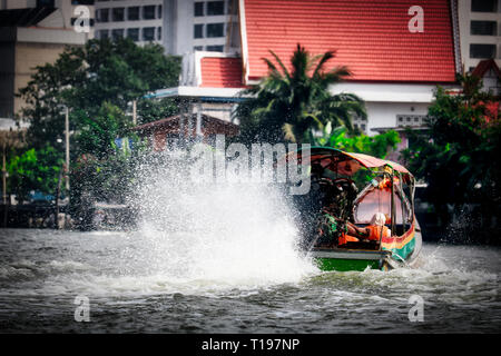 Dieses einzigartige Foto zeigt wie die alten traditionellen Long tail Boote an der Mae Nam Chao Phraya Fluss in Bangkok fahren Stockfoto