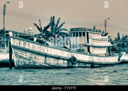 Dieses einzigartige Bild zeigt einen alten verworfen Geisternetze Boot auf dem Mae Nam Chao Phraya Fluss in Bangkok. Stockfoto