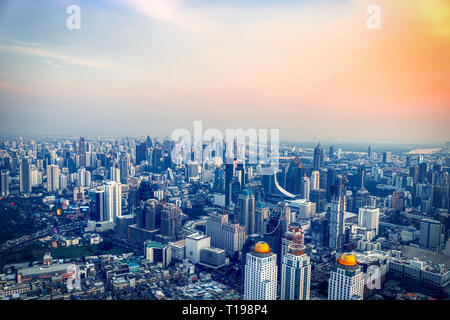 Dieses einzigartige Foto zeigt den spektakulären Sonnenuntergang in Bangkok, Thailand. Sie können sehen, wie sich die Stadt in der Abendsonne leuchtet mit einer großen Wolke Stockfoto