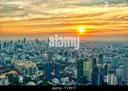 Dieses einzigartige Foto zeigt den spektakulären Sonnenuntergang in Bangkok, Thailand. Sie können sehen, wie sich die Stadt in der Abendsonne leuchtet mit einer großen Wolke Stockfoto