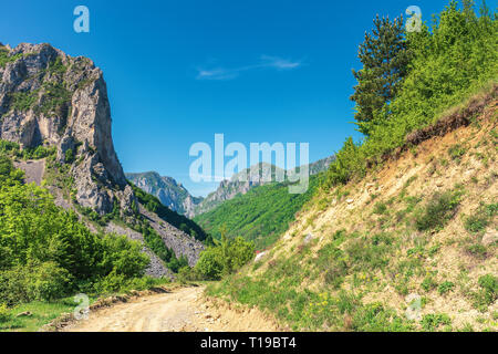 Frühling in Alba land rumänien. wunderbar sonniger Tag in bergiger Landschaft. Straße in den Canyon mit hängenden Felsen unter dem klaren, blauen Sk Stockfoto