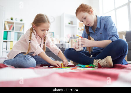 Zwei Mädchen mit Spielzeug spielen zu Hause Stockfoto