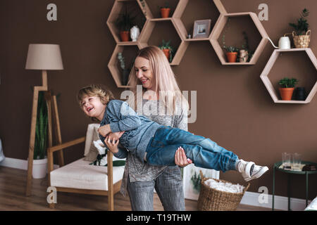 Freundliche kleine Junge Spaß mit Mutter auf dem Sofa Stockfoto