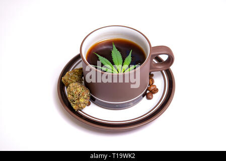 Detail von Cannabis Kaffee Tasse mit Marihuana Blätter und Kaffeebohnen isoliert über Weiß, Marihuana edibles Konzept Stockfoto