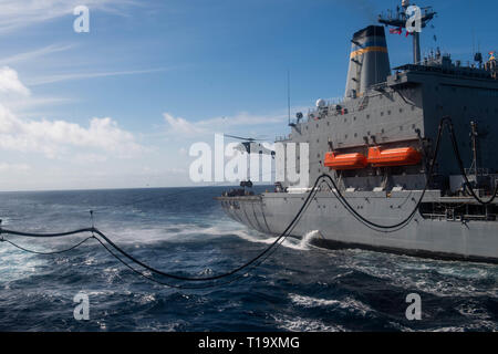 190323-N-HD 110-0019 PAZIFISCHEN OZEAN (23. März 2019) Einem MH-60S Sea Hawk Hubschrauber, Hubschrauber Meer Combat Squadron (HSC) 21, nimmt speichert, die von der Flotte Auffüllung öler USNS Yukon (T-AO202), rechts, Harpers Ferry-Klasse amphibische Landung dock Schiff USS Harpers Ferry (LSD 49), während eine Auffüll-anforderung auf See. Harpers Ferry ist unterwegs die Durchführung von Routineaufgaben als Teil der USS Boxer Amphibious Ready Group (ARG) im östlichen Pazifik. (U.S. Marine Foto von Mass Communication Specialist 3. Klasse Danielle A. Baker) Stockfoto