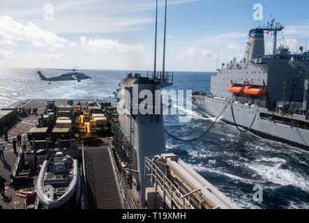 190323-N-HD 110-0069 PAZIFISCHEN OZEAN (23. März 2019) Einem MH-60S Sea Hawk Hubschrauber, Hubschrauber Meer Combat Squadron (HSC) 21 Tropfen liefert auf dem Flugdeck der Harpers Ferry-Klasse amphibische Landung dock Schiff USS Harpers Ferry (LSD 49) während einer Auffüllung-auf-See mit Fleet Auffüllung öler USNS Yukon (T-AO 202). Harpers Ferry ist unterwegs die Durchführung von Routineaufgaben als Teil der USS Boxer Amphibious Ready Group (ARG) im östlichen Pazifik. (U.S. Marine Foto von Mass Communication Specialist 3. Klasse Danielle A. Baker) Stockfoto