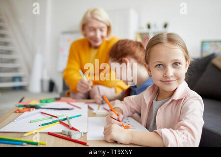 Süße Mädchen auf Kamera beim Zeichnen Stockfoto