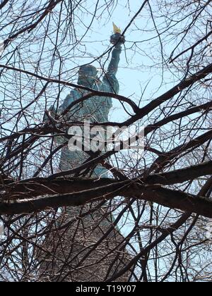 Freiheitsstatue von hinten durch Äste gesehen Stockfoto