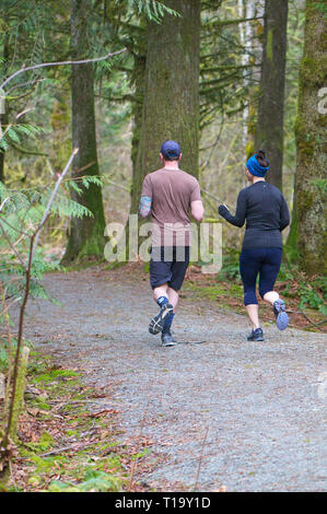 Junges Paar auf einem Trail in einem Waldgebiet von Cliff Falls Park, Maple Ridge, B.C. Stockfoto