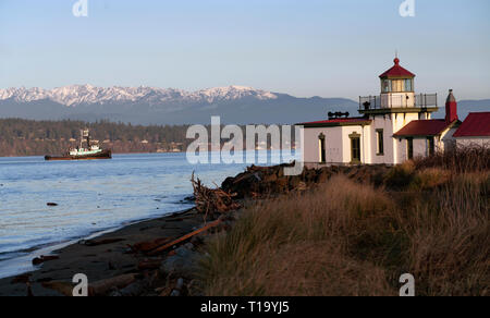 Ein Boot übergibt West Point Lighthouse in der Puget Sound in der Morgendämmerung Stockfoto