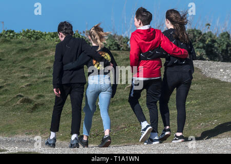 Jugendliche mit ihren Armen um sich gegenseitig einen Fußweg entlang zu laufen. Stockfoto