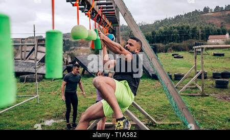 Teilnehmer Hindernisparcours suspension tun Stockfoto