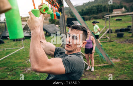 Teilnehmer Hindernisparcours suspension tun Stockfoto