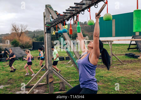 Teilnehmer Hindernisparcours suspension tun Stockfoto