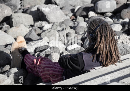 Im mittleren Alter weißer Mann mit Dreadlocks Kopfhörer tragen. Stockfoto