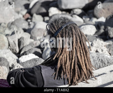 Im mittleren Alter weißer Mann mit Dreadlocks Kopfhörer tragen. Stockfoto