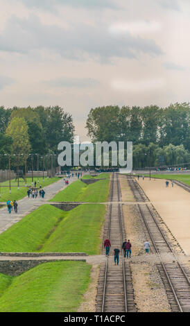 Oswiencim, Polen - 21. September 2019: Touristen zu Fuß entlang der Bahnlinie, wo der Wagen mit der Birkenau Gefangenen angekommen. Stockfoto