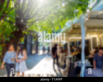 Abstrakte verschwommen Menschen zu Fuß auf Flohmarkt Hintergrund mit Sonnenlicht. Stockfoto