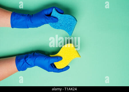 Weibliche Hände Reinigung auf blauem Hintergrund. Reinigung oder die allgemeine Ordnung und Sauberkeit Konzept Hintergrund. Kopieren Sie Platz. Flach, Ansicht von oben. Frühjahrsputz Konzept. Stockfoto