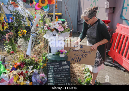 Eine Insel Waiheke Frau aus dem Norden der Insel mit ihrem Partner und zwei Hunde reisten, legte sie ein Plakat, auf dem stand, "Liebe und Mitgefühl wird immer gewinnen', wie sie für die 50 Opfer der Moscheen Terroranschläge zahlt. Rund 50 Personen wurde angeblich in der Christchurch getötet Moscheen Terroranschlag schießen Targeting die Masjid Al Noor Moschee und die linwood Moschee. Stockfoto