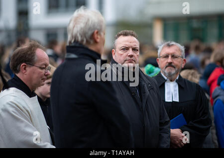 Haltern am See, Deutschland. 25 Mär, 2019. Gregor Coerdt (L-R), Katholische Seelsorge Offizier in der Pfarrei St. Sixtus, Haltern am See, Schulleiter Ulrich Wessel, Bodo Klimpel, Bürgermeister der Stadt Haltern und Karl Henschel, Evangelischer Pfarrer der Pfarrei, in Haltern stehen auf dem Schulhof der Joseph König Gymnasium in den Französischen Alpen der 4. Jahrestag der Germanwings crash zu gedenken. Nach Angaben der Ermittlungsbehörden, die co-pilot absichtlich zum Absturz des Airbus A320 von Barcelona nach Düsseldorf im Süden von Frankreich am 24. März 2015. Alle 150 Personen o Quelle: dpa p Stockfoto