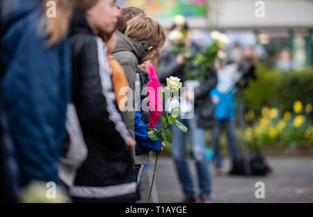 Haltern am See, Deutschland. 25 Mär, 2019. Ein Schüler steht mit einem weißen auf dem Schulhof der Joseph König Gymnasium Rose anlässlich der Gedenkfeier zum 4. Jahrestag der Germanwings Crash in den Französischen Alpen. Nach Angaben der Ermittlungsbehörden, die co-pilot absichtlich zum Absturz des Airbus A320 von Barcelona nach Düsseldorf im Süden von Frankreich am 24. März 2015. Alle 150 Menschen an Bord ums Leben gekommen. Unter ihnen waren 16 Schüler und 2 Lehrer aus Haltern am See. Alle Schüler und Lehrer sowie dem Bürgermeister und den Vertretern der Kirche nehmen Teil an der Gedenkfeier cere Quelle: dpa p Stockfoto