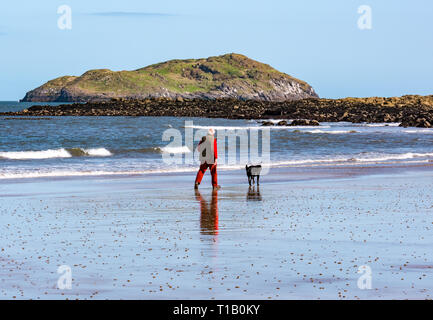 Firth-of-Forth, East Lothian, Schottland, Vereinigtes Königreich, 25. März 2-19. UK Wetter: Frühling Sonnenschein an der Küste, das ist ein Teil des John Muir, mit Menschen im Freien genießen. Ein älterer Mann seine Hunde am Strand bei Ebbe mit Craigleith Insel am Horizont Stockfoto