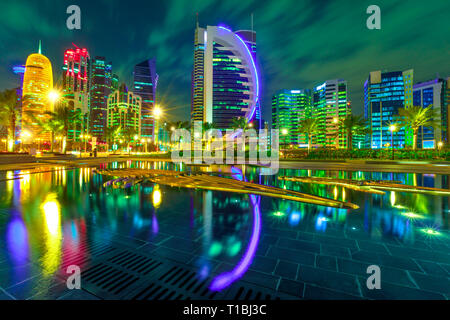 Doha West Bay high steigt in der Nacht in der Innenstadt Park wider beleuchtet. Bunt verglasten Wolkenkratzer der Skyline von Doha, Katar, im Nahen Osten, 1001 Stockfoto