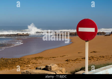 Keinen Eintrag Verkehrs schild am Eingang zum Strand mit goldenem Sand. Wellen auf dem felsigen Ufer gebrochen. Horizont auf den Atlantischen Ozean und den blauen Himmel. Stockfoto