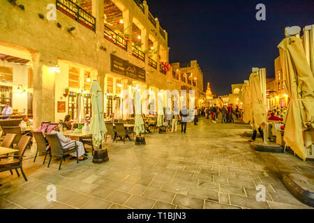 Doha, Katar - Februar 17, 2019: Street View in Souq Waqif Markt mit Cafés und Restaurants sowie das fanar Islamischen Kulturzentrum mit Spirale Moschee Stockfoto