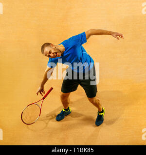 Betonte tennis player werfen und Brechen einen Schläger in Zorn und Wut am Hof. Menschliche Emotionen, Niederlage, Crash, Ausfall, Verlust Konzept. Stockfoto