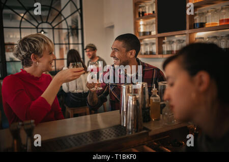 Lachen Freunde Getränke, zusammen in einer Bar in der Nacht Stockfoto