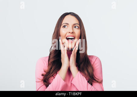 Junge glücklich und überrascht, Frau Suchen links und hält Wangen von Hand isoliert auf weißem Hintergrund. Wow Gesicht Konzept Stockfoto